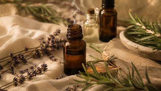 Amber essential oil bottles and dried rosemary on cream linen — aromatherapy and the olfactory system