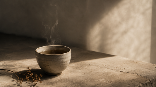 Single ceramic cup with steam on aged stone — slow living and ritual mindfulness