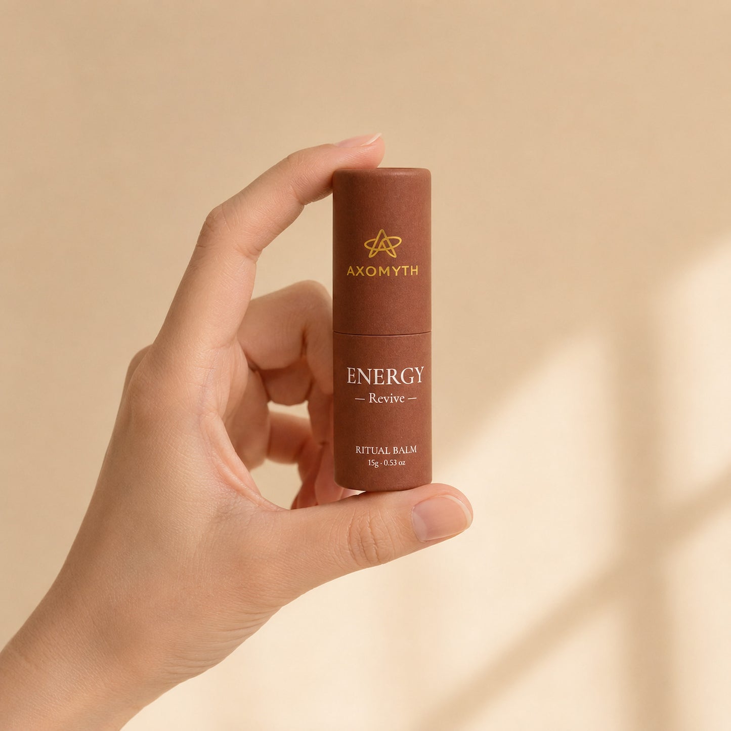 AXOMYTH ENERGY ritual balm held between fingers, showing true size
