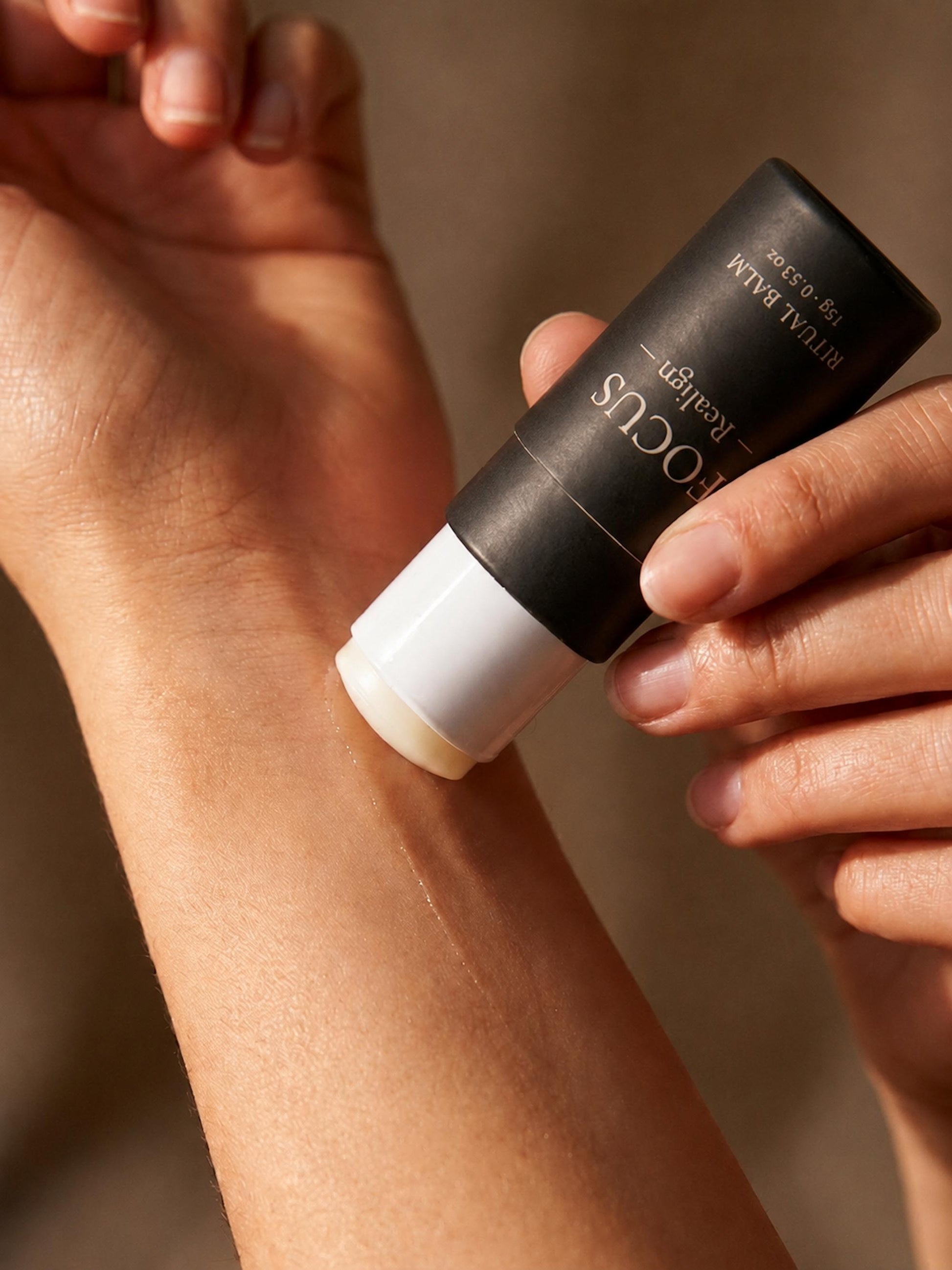 Applying AXOMYTH FOCUS ritual balm to the wrist, close-up