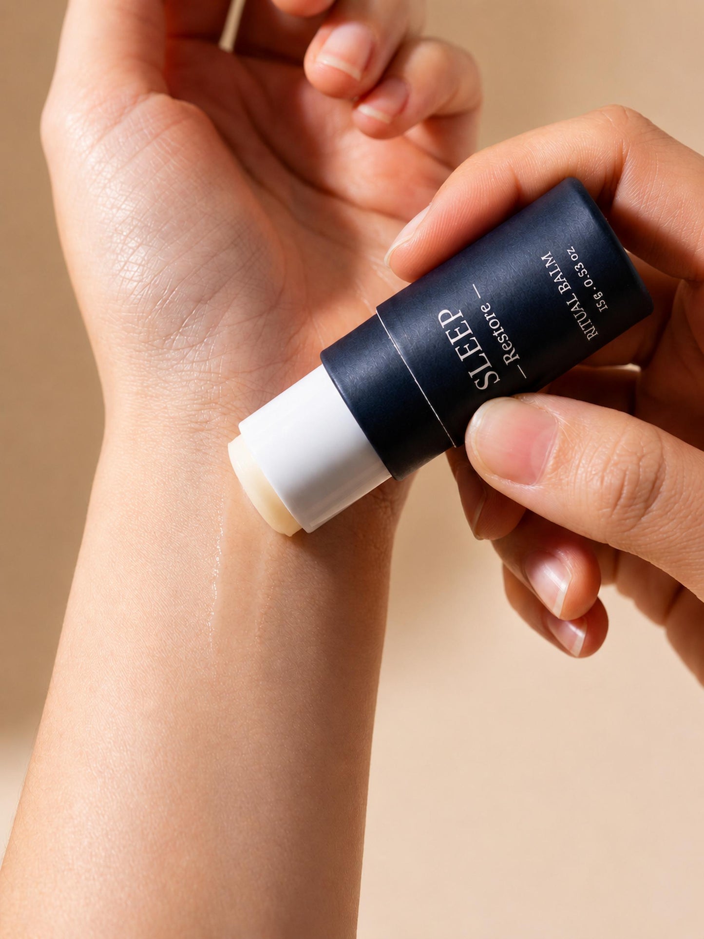Applying AXOMYTH SLEEP ritual balm to the wrist, close-up