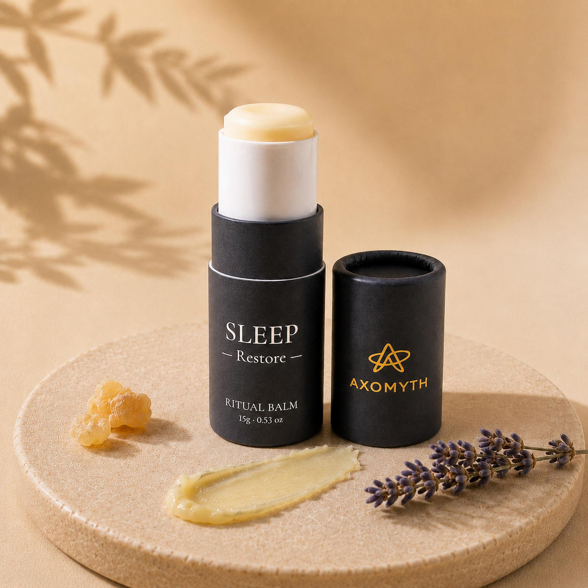 AXOMYTH SLEEP Restore ritual balm open beside its cap, balm texture, lavender and resin on a warm stone surface
